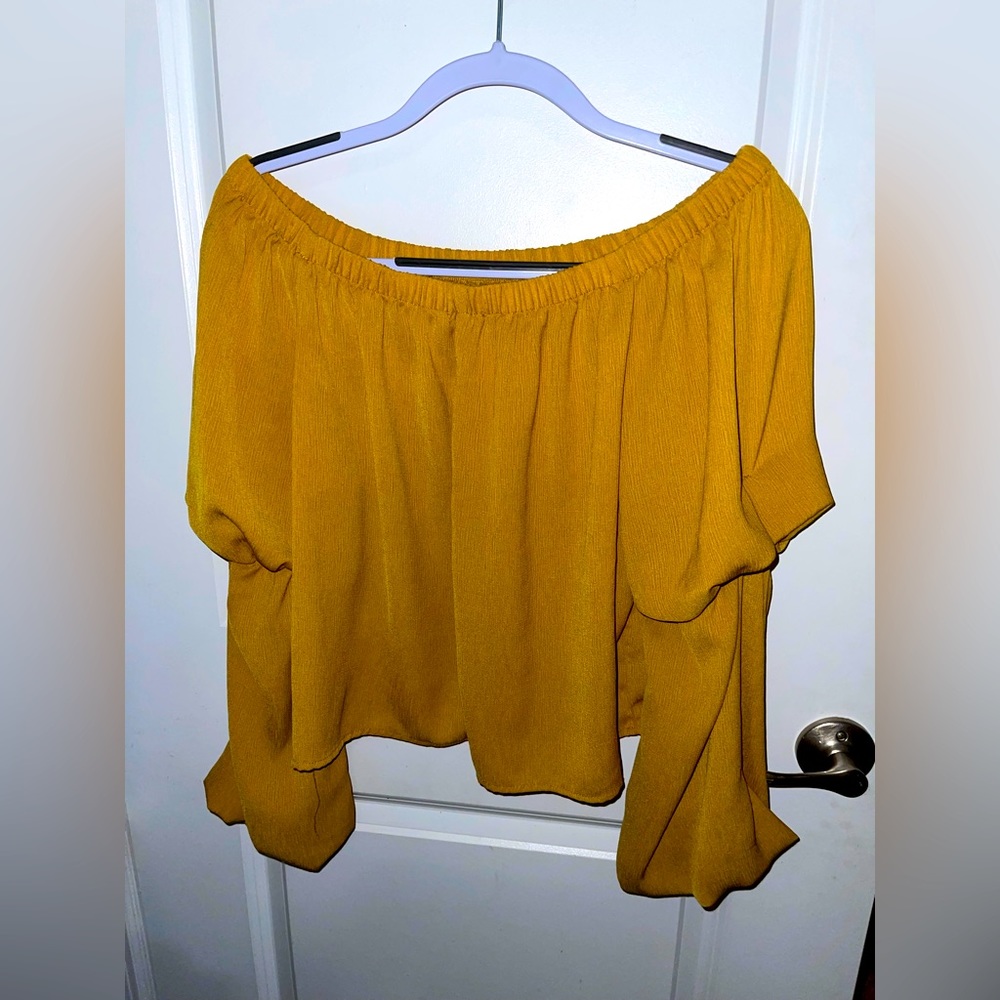 Off shoulder mustard color blouse.